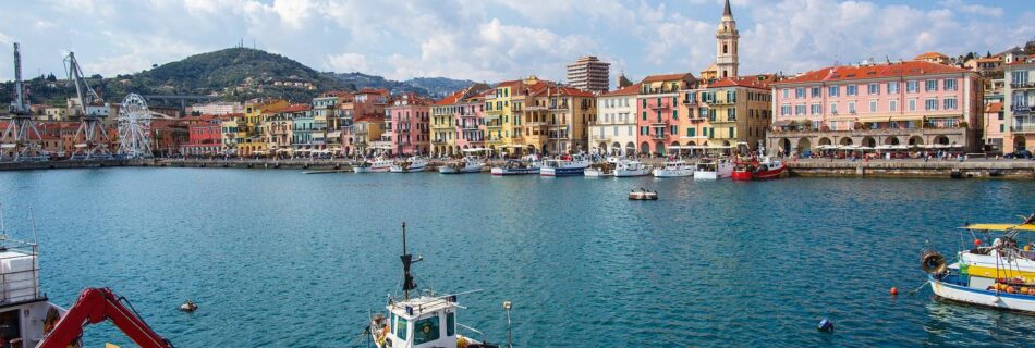 Bunter Hafen von Imperia mit farbenfrohen Häuserreihen, Fischerbooten und klarblauem Wasser an der ligurischen Küste.